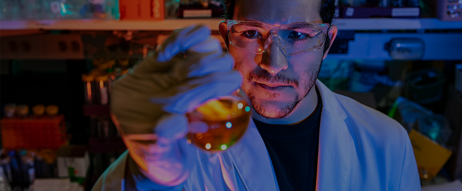 Male student in a laboratory examining an object